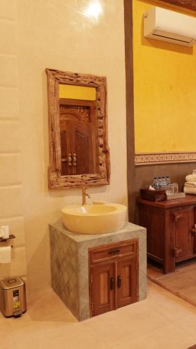 a bathroom with a sink and a mirror at Rumah Dharma Boutique Villa in Magelang