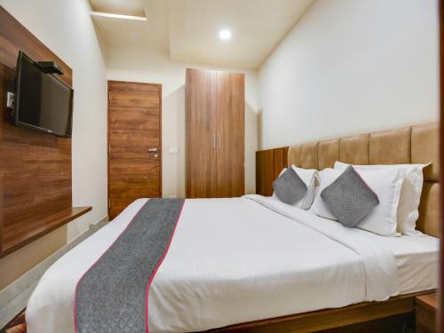 a bedroom with a bed with a tv on the wall at Hotel Ludhiana Regency in Ludhiana