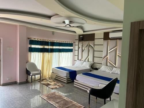 a bedroom with two beds and a chair at I Light Beach Resort in Mandarmoni