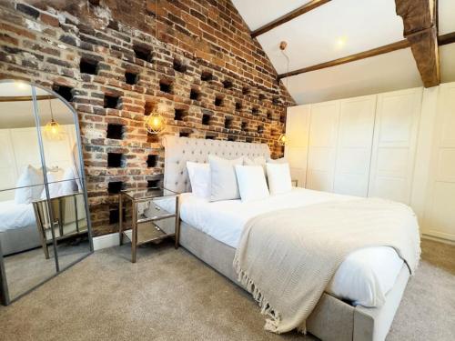 Un dormitorio con una pared de ladrillo y una cama grande en Whitkirk Cottage en Leeds