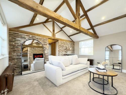 a living room with a white couch and a brick wall at Whitkirk Cottage in Leeds
