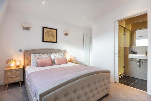 a bedroom with a large bed with pink pillows at Farringdon/St Pancras penthouse in London