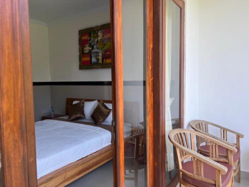 a small bedroom with a bed and a mirror at Kailash Homestay in Padangbai