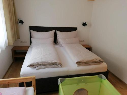 1 dormitorio con 1 cama grande con sábanas blancas en Ferienwohnung umemma, en Kappl