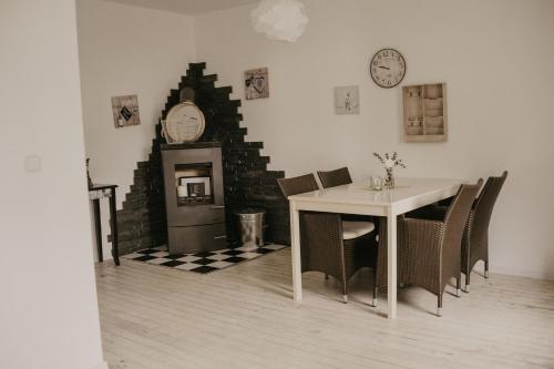 a dining room with a table and a clock on the wall at Ferienwohnung Häserhof in Raddestorf