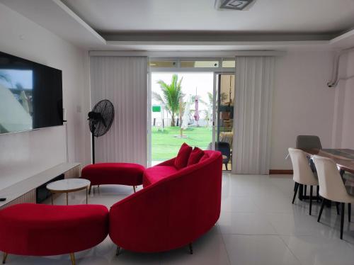 a living room with a red couch and chairs at Seaview Emerald Adoces Beach Resort in Morong
