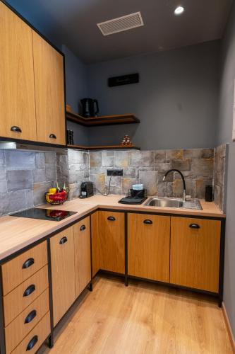 a kitchen with wooden cabinets and a sink at Kraka Apartments in Leonidion