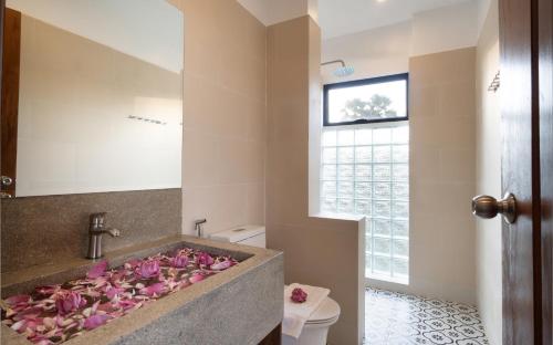 a bathroom with pink flowers in a bath tub at The Nature & Villas in Siem Reap