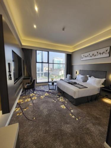 a bedroom with a large bed and a large window at Msharef almoden hotel فندق مشارف المدن in Riyadh
