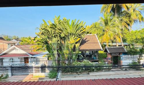 a view from a window of a house with palm trees at Singrarat Hotel in Luang Prabang