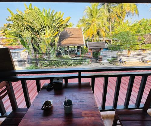 a table on a balcony with a view of a building at Singrarat Hotel in Luang Prabang