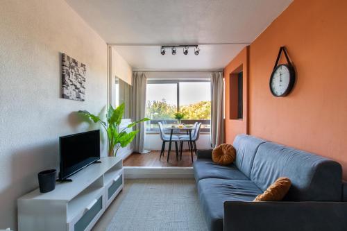 sala de estar con sofá azul y TV en L'étang de l'or *Joli T2 * Plage à 10 min * Proche Montpellier en Carnon-Plage