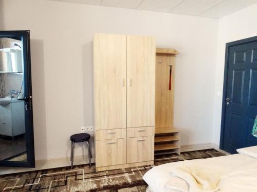 a bedroom with a wooden cabinet and a mirror at Apartments EMIZA in Samokov