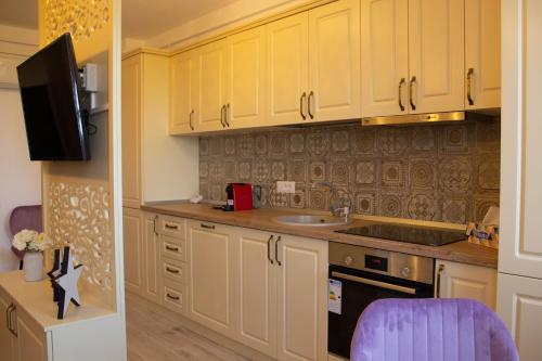 a kitchen with yellow cabinets and a sink at Blue Joy Bukovina Aparthotel in Suceava
