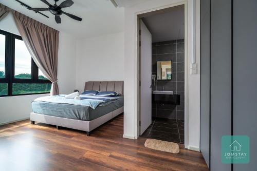 a bedroom with a bed and a bathroom with a shower at JOMSTAY Sunway Onsen Suites Ipoh - Lost World of Tambun Ipoh Waterpark in Tambun