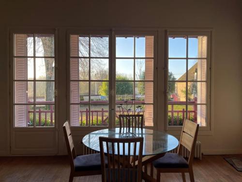une salle à manger avec une table, des chaises et des fenêtres dans l'établissement Demeure de charme à Sancerre, à Saint-Satur