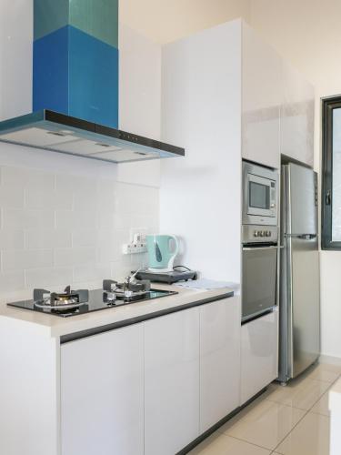 a white kitchen with a stove and a refrigerator at Beacon Executive Suite by Uptrend Home Management in George Town