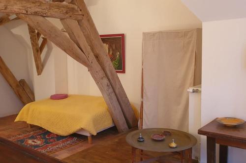 une petite chambre avec un lit et une table dans l'établissement Demeure de charme à Sancerre, à Saint-Satur