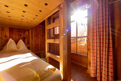 a bedroom with a bed and a window in a cabin at Berggasthof Loosbühelalm in Grossarl