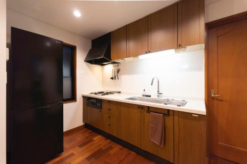 a kitchen with a black refrigerator and a sink at Minato-ku - House - Vacation STAY 14528 in Tokyo