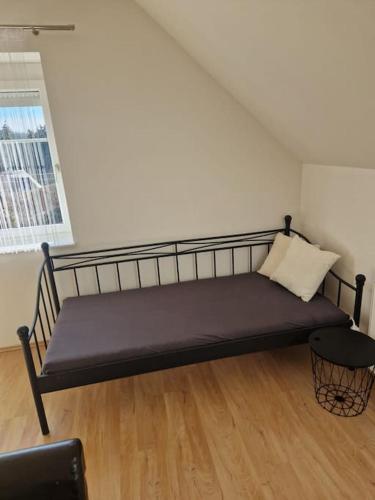 Un banco negro en una habitación con ventana. en Apartment am Stadtrand zu Graz, en Graz