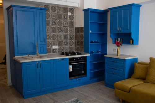 a kitchen with blue cabinets and a stove at Blue Joy Bukovina Aparthotel in Suceava