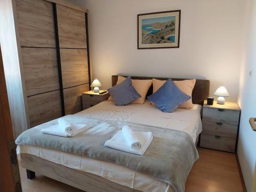 a bedroom with a bed with two towels on it at Apartment Ante K A1 in Metajna