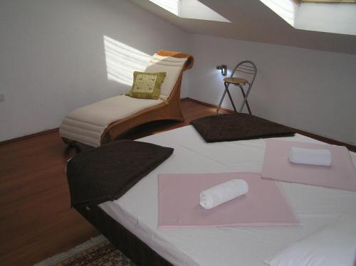 a bedroom with a bed and a chair with a pink envelope at Apartments Villa Ypsilon in Sveta Nedelja