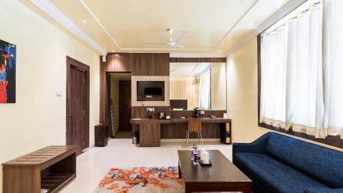 een woonkamer met een blauwe bank en een tafel bij Niranjana Hotel Bodhgaya in Bodh Gaya