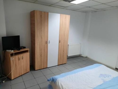 a bedroom with a bed and a cabinet and a television at Apartament Del Dodo in Alba Iulia