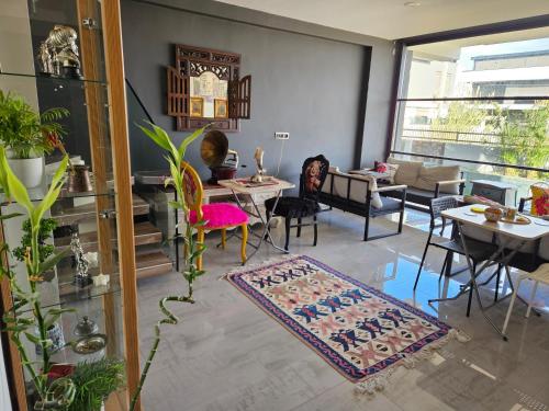 uma sala de estar com mesas e cadeiras e um tapete em Oldskool Villas em Lara