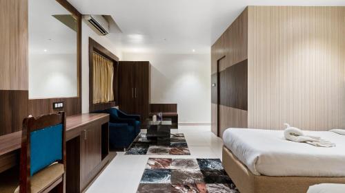 a hotel room with a bed and a desk at Niranjana Hotel Bodhgaya in Bodh Gaya