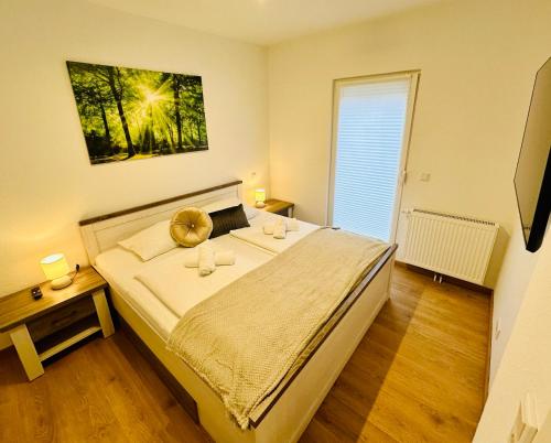 ein Schlafzimmer mit einem großen Bett und einem Fenster in der Unterkunft FeWo Buche mit Balkon in Bad Harzburg