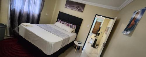 a bedroom with a large bed and a mirror at Gentle home in Pretoria