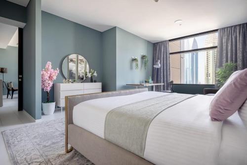 ein Schlafzimmer mit einem großen Bett und blauen Wänden in der Unterkunft Frank Porter - Index Tower in Dubai
