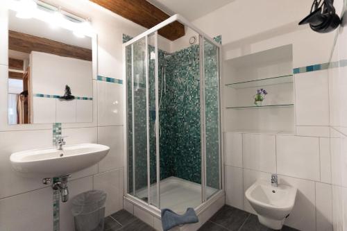 W łazience znajduje się prysznic, umywalka i toaleta. w obiekcie Hotel Pension Kandolf w mieście Tamsweg