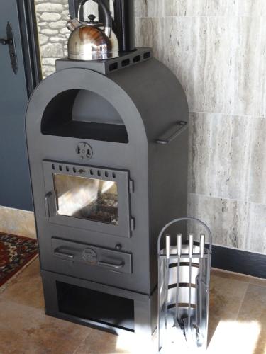 a wood stove in a living room with a bowl at Apartments EMIZA in Samokov