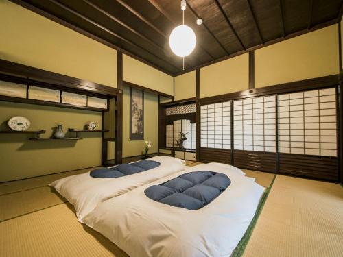 a bedroom with a large bed with blue pillows at 瀧乃元 近藤家（Kondoke-Inn) in Toon
