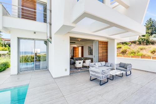 een huis met een zwembad en een terras met meubilair bij Akamas Bay Villa 42 by BeCyprus in Neo Chorio