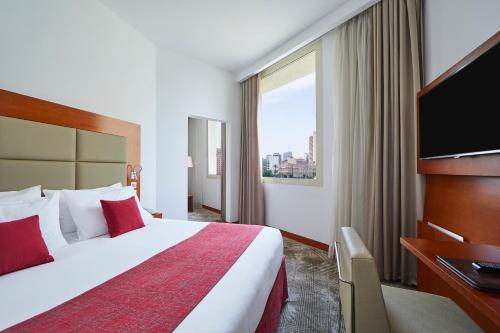 um quarto de hotel com uma cama e uma televisão de ecrã plano em Steigenberger Hotel El Tahrir Cairo no Cairo