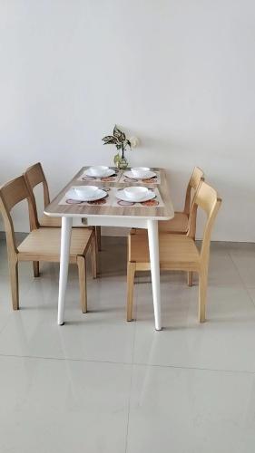 a white table with two chairs and a table with plates at 密月之家19 in Kampong Pok Kechil