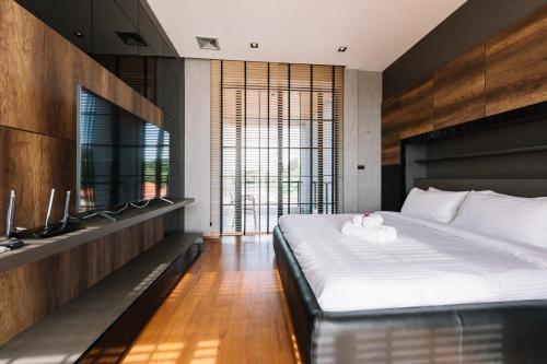 a bedroom with a large bed and a large window at Beforesunset in Ban Chang Kham Luang