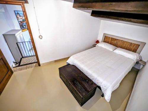 een slaapkamer met een bed met een houten hoofdeinde bij Case al Borgo-Agira Centre-Home Relais in Agira