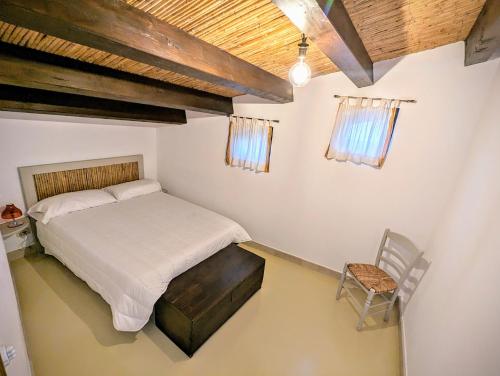 ein Schlafzimmer mit einem Bett und einem Stuhl in der Unterkunft Case al Borgo-Agira Centre-Home Relais in Agira