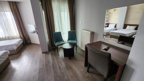 a hotel room with a desk and a mirror at Hotel Rile Men Blue in Niš