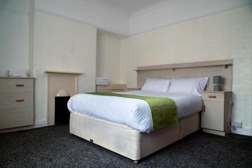 um quarto com uma cama grande e um cobertor verde em Amarillys Guest House em Preston