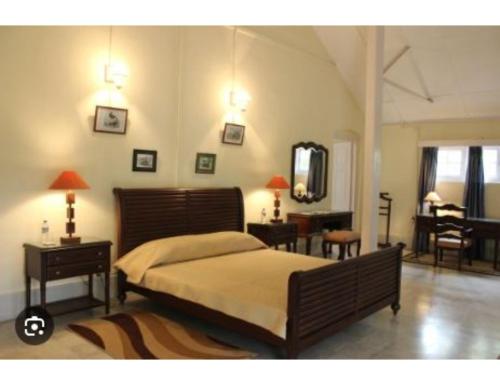 Schlafzimmer mit einem Bett, einem Tisch und einem Spiegel in der Unterkunft Serene Guest House, Pasighat, Arunachal Pradesh in Pasighat