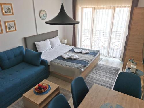 Una sala de estar con una cama y un sofá azul. en Ski&Spa Milmari L17, en Kopaonik