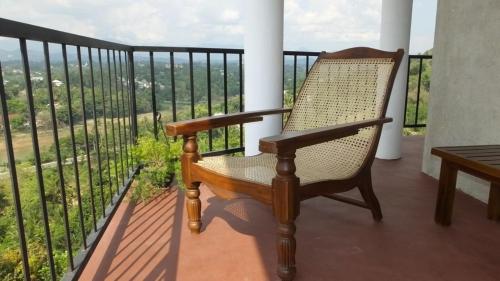 a rocking chair on a balcony with a view at Villa Arunalu Kandy in Kandy