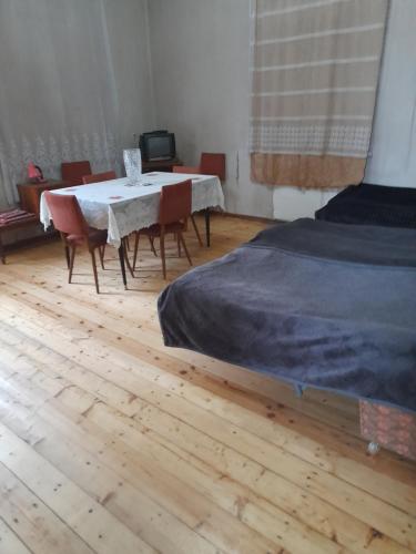 Levani's GuestHouse في زوغديدي: غرفة مع طاولة وكراسي وسرير